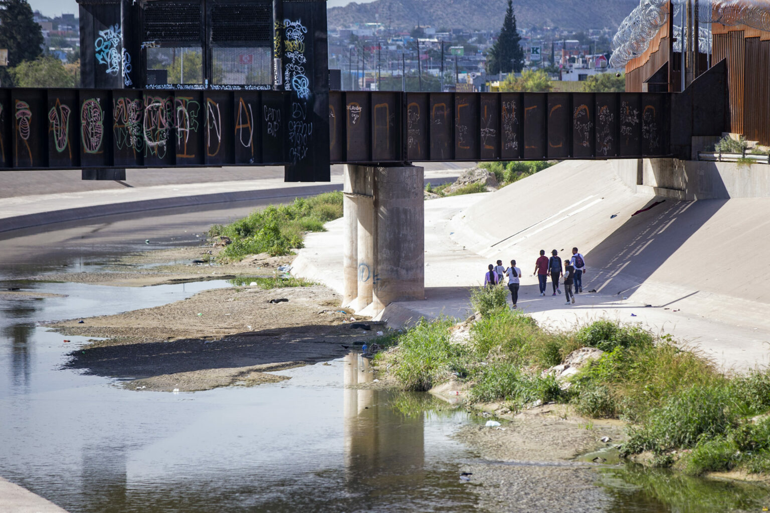 Immigrants walk along the U.S. side of the border in El Paso. 