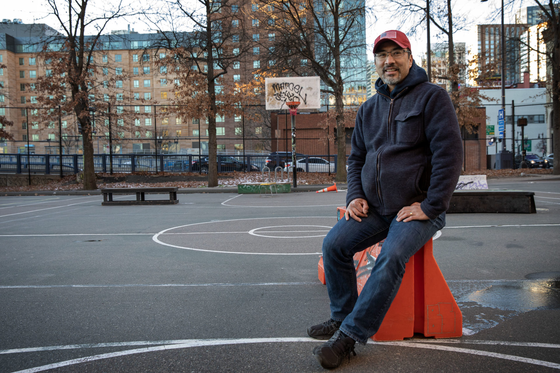 Russell Eng, president of Friends of Reggie Wong Park, stands at the center of the park on a winter evening. 