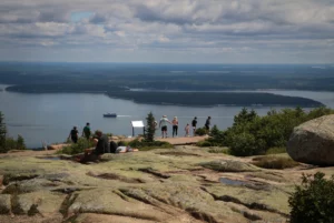 Tourists on the summit of Cadillac Mountain, in Acadia National Park. Signs direct visitors to stay on the path, to avoid trampling sensitive mountain flora.