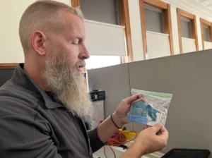 Andrew Warner holding some of the supplies he gives out as part of his harm reduction work. Warner, then an outreach worker for the treatment provider Better Life Partners, is now Manchester's director of overdose prevention.