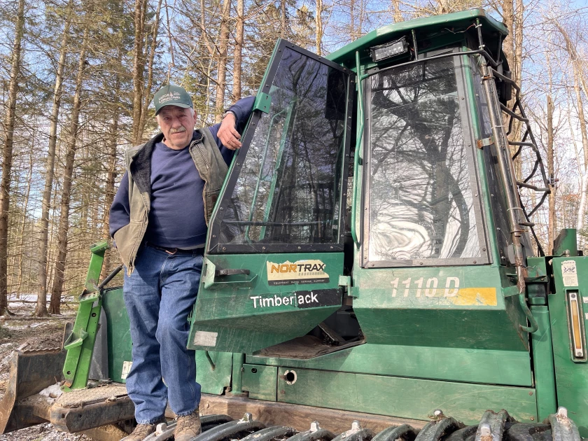 Brian Lafoe, standing outside the cab of his forwarder, says the warm start to winter in Vermont has already taken a toll on his logging business this year.