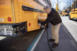 District transportation director Dana Cruickshank unplugs the charging cable from one of Beverly, Mass.'s electric school buses.