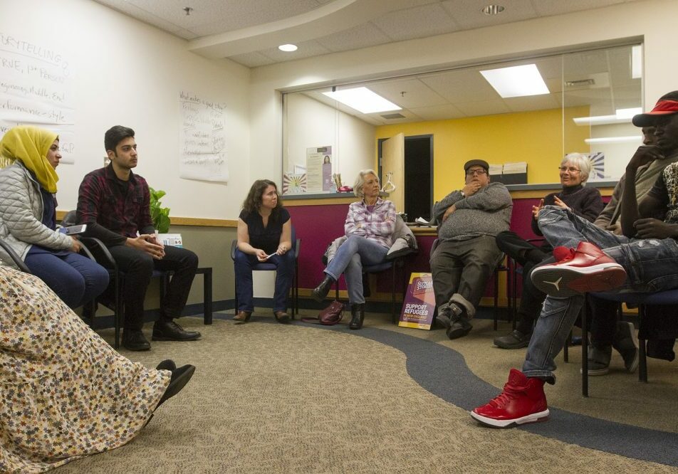 The organizer behind the International Institute of New England and Massmouth's live storytelling collaboration "Suitcase Stories" sees it as a way to break down cultural barriers and turn strangers into neighbors. Here, a group of potential storytellers gather at the International Institute's Lowell office for a storytelling workshop. Photo by Joe Difazio for WBUR