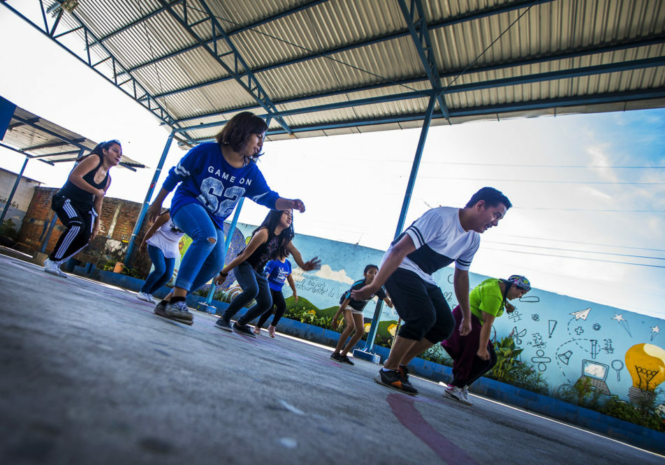 Volunteers for Glasswing International lead members of the Glee club in a dance routine at a school in Las Palmas, San Salvador, El Salvador. Photo by Jesse Costa for WBUR