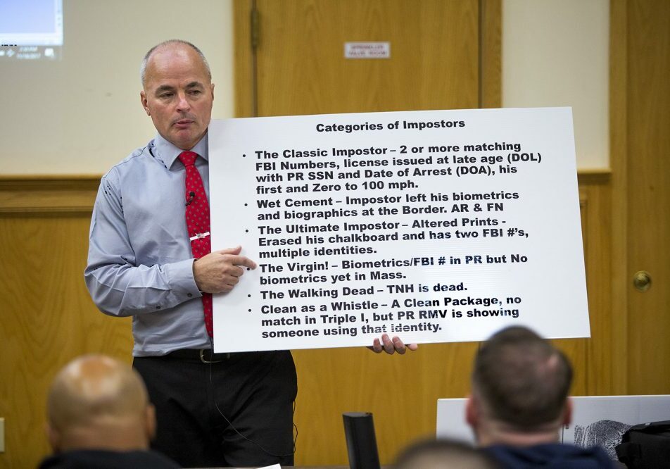 Officer James Scott of the Saugus Police Department holds up a placard with the categories of so-called "impostors" during an impostor training class at Bristol County Jail and House of Correction in North Dartmouth. Photo by Jesse Costa for WBUR