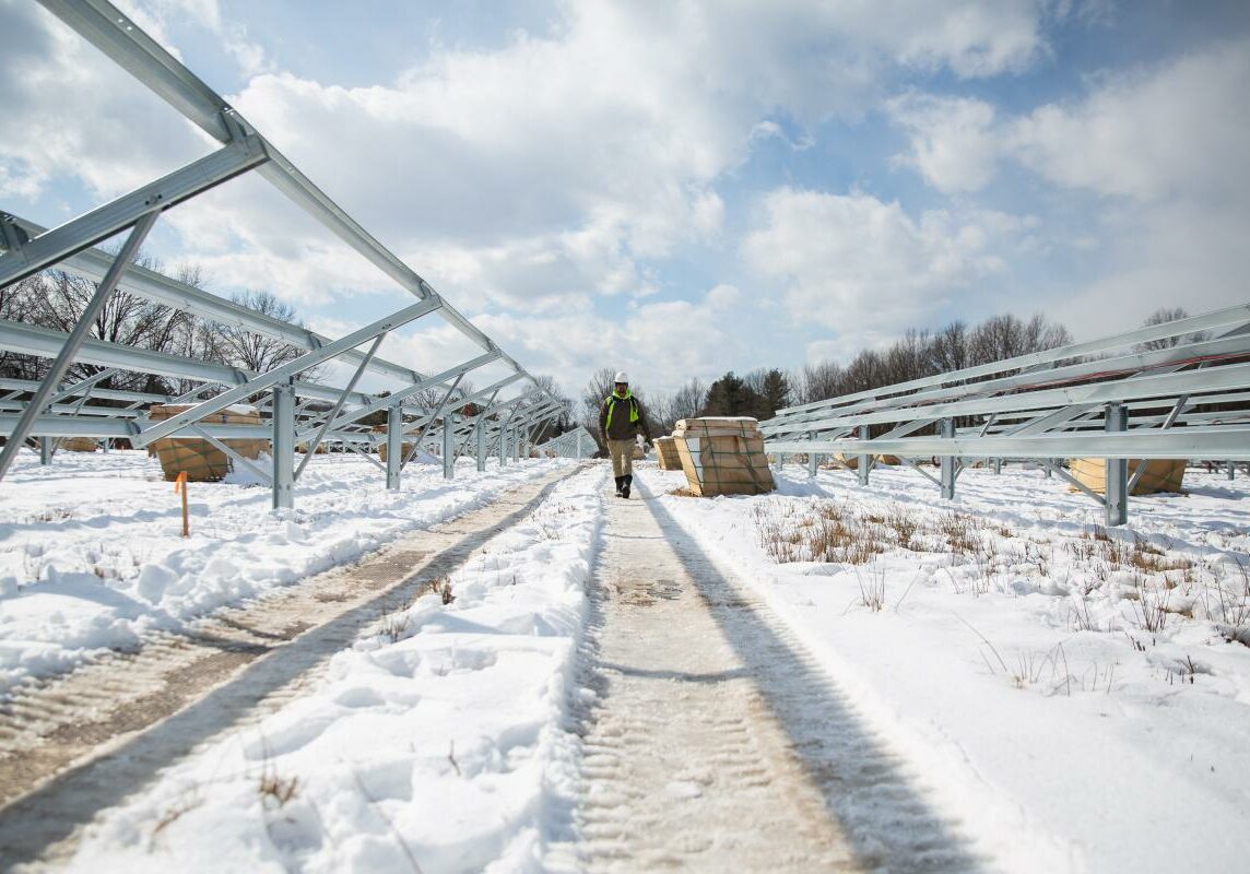 Nick Sone walks between panel frames at the Bloomfield array. Workers at CTEC Solar are optimistic this pilot program will show the value of shared, community-driven solar. Photo by Ryan Caron King for Connecticut Public Radio