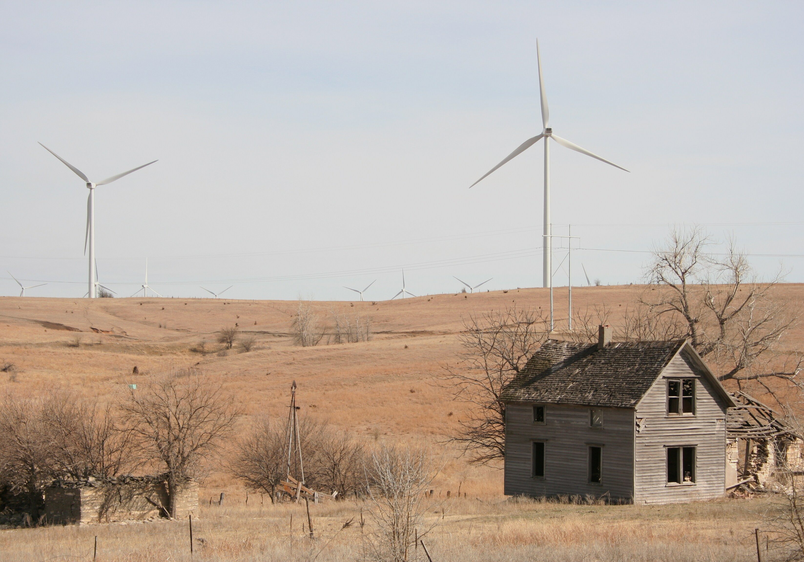 Abandoned farmhouse with turbines in background. Meridian Way Wind Farm, Cloud County, Kansas. Photo by Phil Warburg