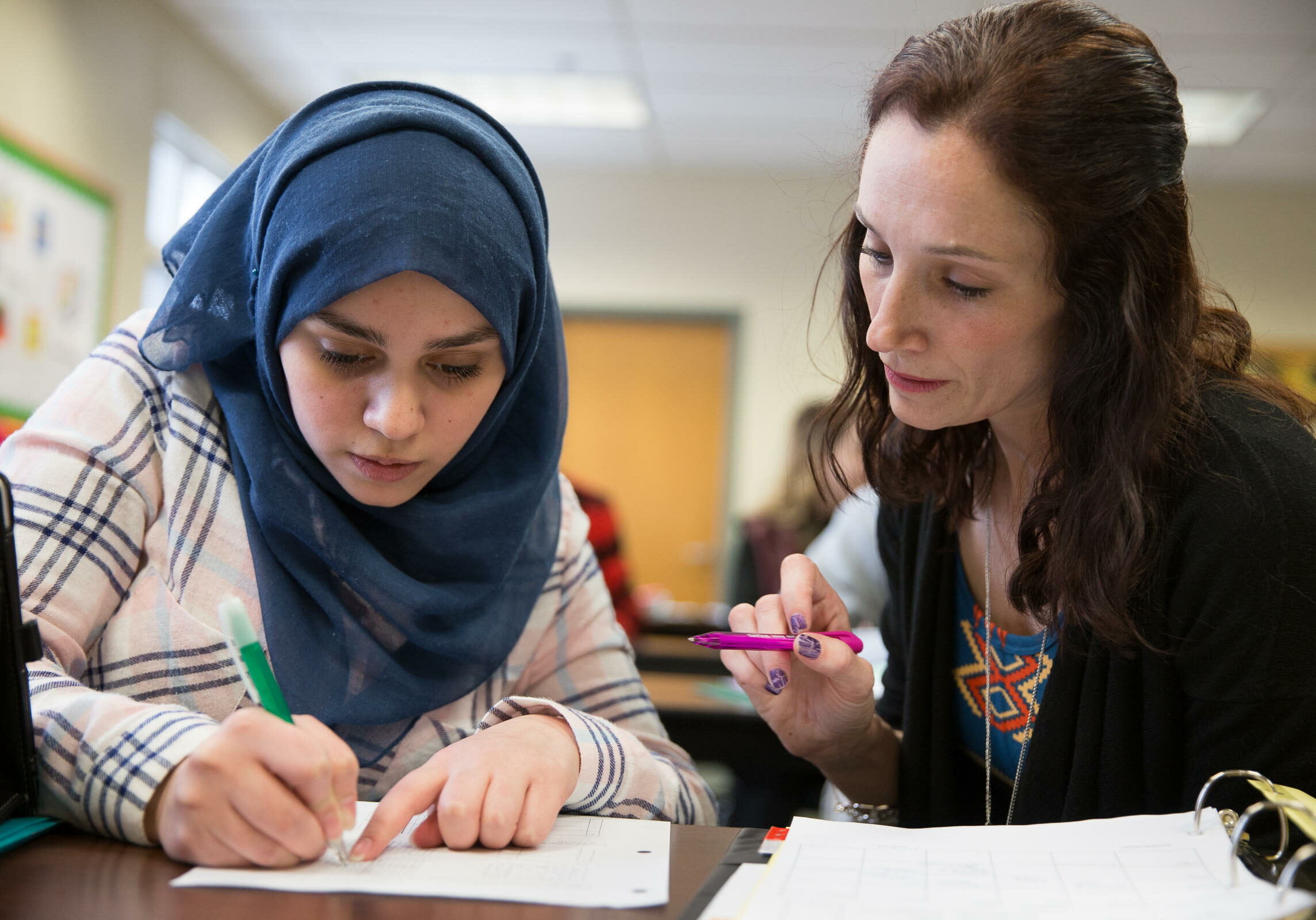 Ghena works on math schoolwork with her guided study teacher Karen Stark . Photo by Ryan Caron King for NENC