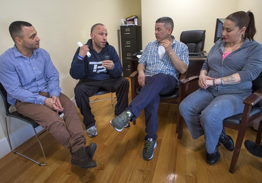 From left to right: Felito Diaz, Julio Cesar Santiago, Richard Lopez and Irma Bermudez speak at Casa Esperanza, a collection of day treatment, residential programs and transitional housing in Roxbury. Photo by Jesse Costa for WBUR